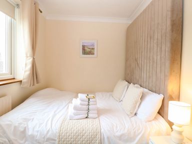 A bedroom with a bed and towels at Oldfields, Bury St Edmunds