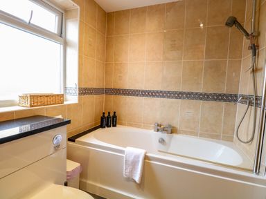 A bathroom with a bathtub and shower at Oldfields in Bury St Edmunds