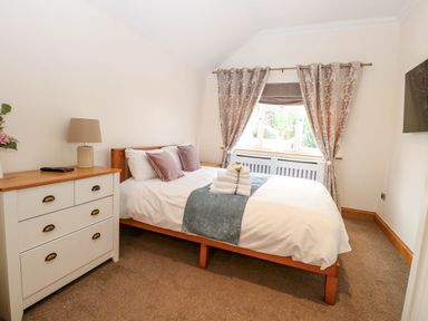 A bedroom with a bed and dresser at Oldfields in Bury St Edmunds