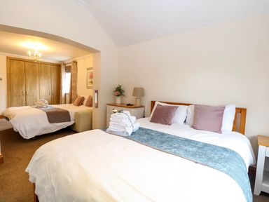 A bedroom with two beds and a wardrobe at Oldfields in Bury St Edmunds