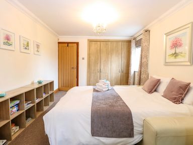A bedroom with a bed and shelving at Oldfields in Bury St Edmunds