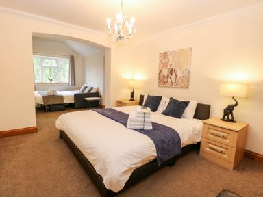 A bedroom with a bed and nightstands at Oldfields in Bury St Edmunds