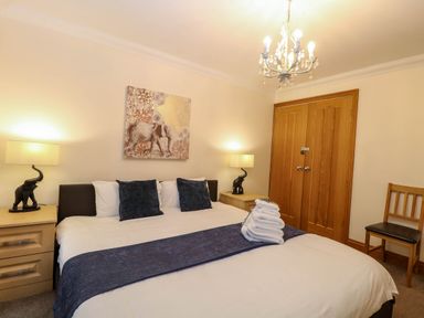 A bedroom with a bed and lamps at Oldfields in Bury St Edmunds