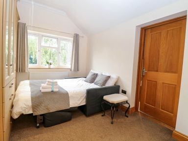 A bedroom with a bed and dresser at Oldfields in Bury St Edmunds