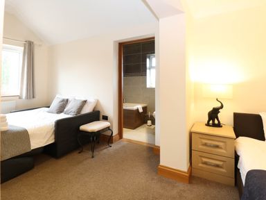 A bedroom with a bed and an adjoining bathroom at Oldfields in Bury St Edmunds