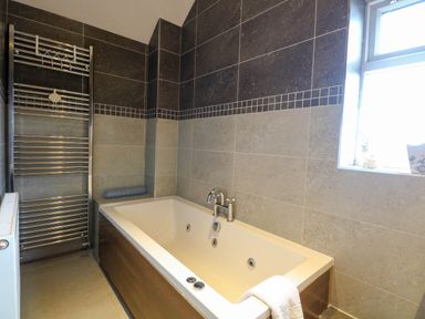A bathroom with a bathtub and radiator at Oldfields in Bury St Edmunds