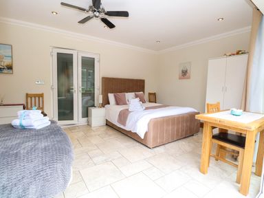 A bedroom with a bed and table at Oldfields in Bury St Edmunds