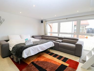 A living room with a sofa and bed at Oldfields in Bury St Edmunds