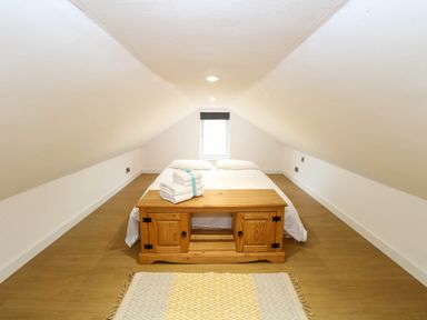 A bedroom with a bed and wooden table at Oldfields in Bury St Edmunds