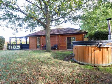 An outdoor area featuring a cabin and hot tub at Oldfields Bury St Edmunds