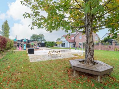 A garden with a playground and picnic table at Oldfields in Bury St Edmunds