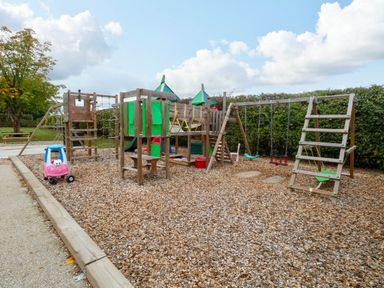 A playground with swings and a climbing structure at Oldfields in Bury St Edmunds