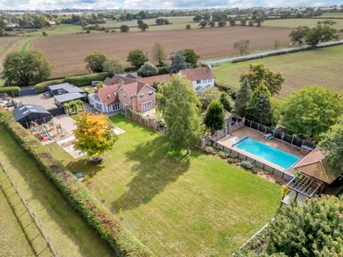 An outdoor view of a house with a swimming pool and garden at Oldfields Spa Mansion with Pool, Sauna and Hot Tub in Bury St Edmunds