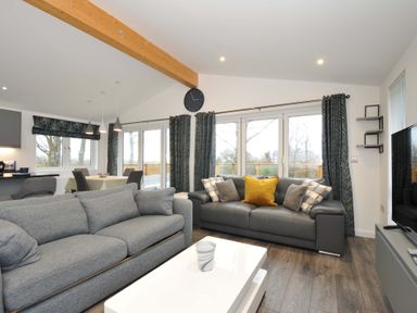 A living room with a gray sofa and white table at 20 Meadow Retreat in Dobwalls