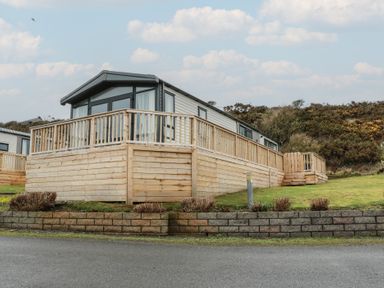 A holiday caravan with decking and garden space at Willow's Way in Stranraer