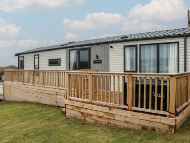 A cabin exterior with a deck and steps at Willow's Way in Stranraer