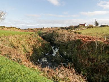 A waterfall near a house in a rural area at Willow's Way Stranraer