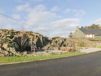 An outdoor area with rock formations and a bench at Willow's Way in Stranraer