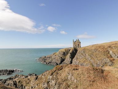 A castle on a cliff by the ocean at Willow's Way in Stranraer