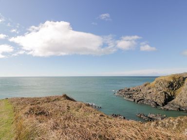 A coastal view with water and rocky shore at Willow's Way in Stranraer