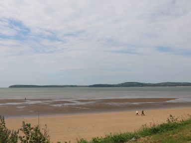 A beach with people walking along the shore at Ard Uisce @ Estuary Bliss, Duncannon, County Wexford