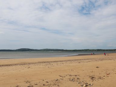 A beach with people walking along the shore at Ard Uisce @ Estuary Bliss Duncannon, County Wexford