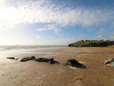 A beach with rocks and water near buildings at Ard Uisce @ Estuary Bliss, Duncannon, County Wexford
