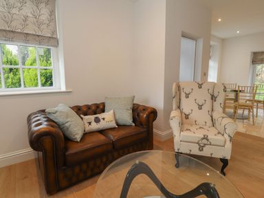 A living room with a sofa and an armchair at The Lodge House in Dolphinholme near Galgate