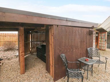 An outdoor area with a table and chairs beside a wooden shed at Tooth Suite Yarm