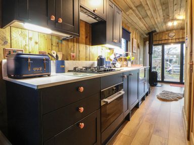 A kitchen with cabinets, sink, and stove at The Suffolk in Knutsford