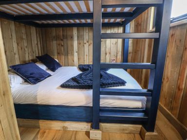 A bedroom with a bed and wooden walls at The Suffolk in Knutsford