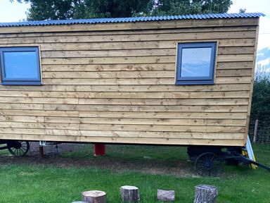 A wooden structure with windows on the side at The Suffolk Hut in Lower Peover, Cheshire