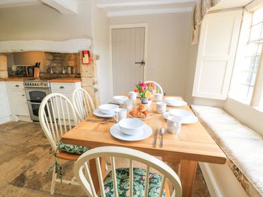 A kitchen with a dining table set for breakfast at The Smithy in Stow on the wold