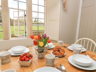 A dining room with a table set for breakfast at The Smithy in Stow on the wold