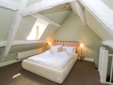 A bedroom with a bed and lamp at The Smithy Stow on the wold