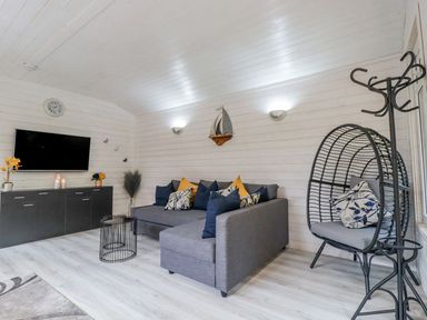 A living room with a television and sofa at St. Chad's Lodge in Bodmin