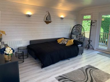 A room with a bed and hanging chair at St. Chad's Lodge in Bodmin