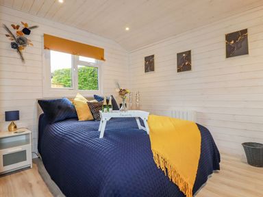 A bedroom with a bed and decorative items at St. Chad's Lodge in Bodmin