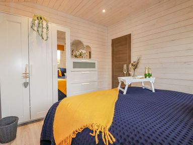 A bedroom with a bed and dresser at St. Chad's Lodge Bodmin