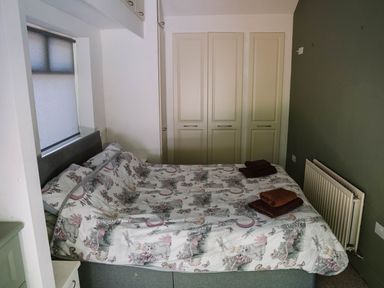 A bedroom with a bed and wardrobe at Carwinley Mill House Cottage near Longtown