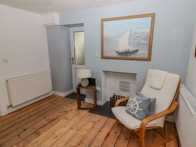 A living room with a painting and an armchair at Rock House in Narberth