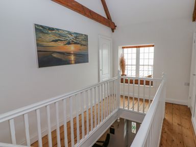 A hallway with a painting and a window at Rock House in Narberth