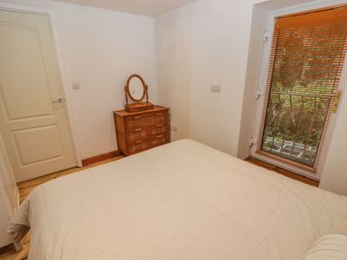 A bedroom with a bed and a dressing table at Rock House in Narberth