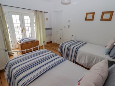 A bedroom with two beds and a chest at Rock House in Narberth