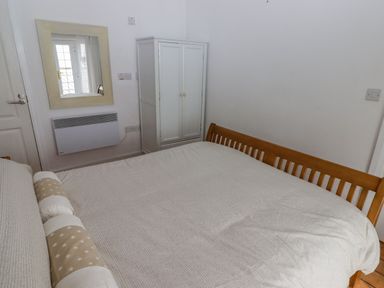 A bedroom with a bed and a wardrobe at Rock House in Narberth