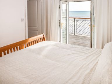 A bedroom with a bed and balcony doors at Rock House in Narberth