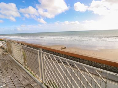 A view of the beach and sea from a balcony at Rock House in Narberth
