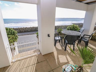 An outdoor area with table and chairs overlooking the sea at Rock House Narberth