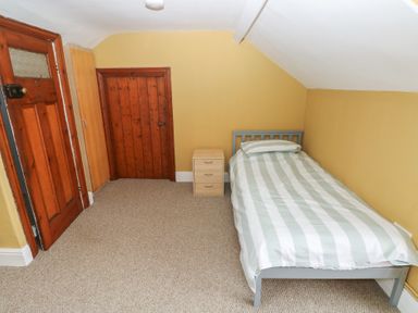 A bedroom with a bed and nightstand at Kenvor in Newport, Pembrokeshire