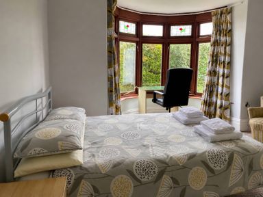 A bedroom with a bed and a chair at Kenvor in Newport, Pembrokeshire